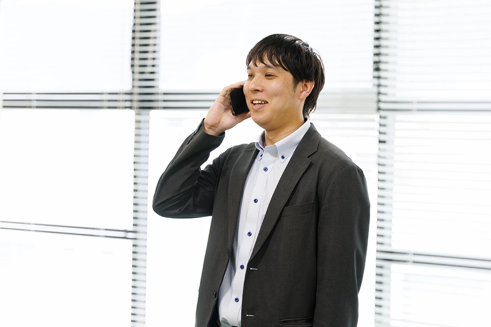電話中の田中秀樹さん